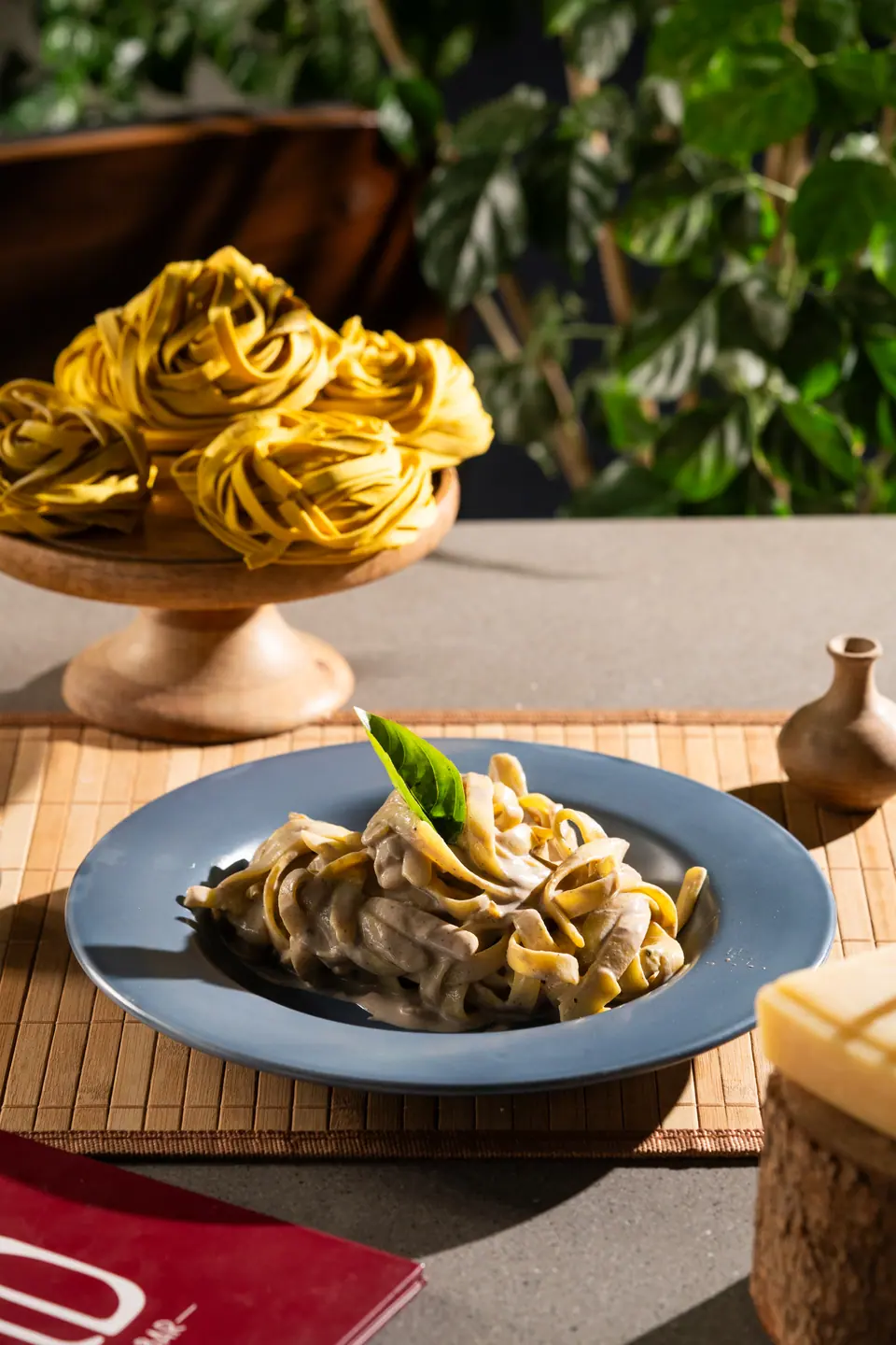 Fresh pasta ribbons gathered into nests on a wooden stand